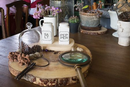 salt and pepper in white bottle as seasoning on wooden table in restaurant with decoration with seasoningの写真素材