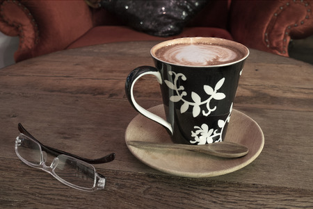 hot coffee with tissue paper coffee on wooden table coffee and sunglasses coffee near red sofaの写真素材