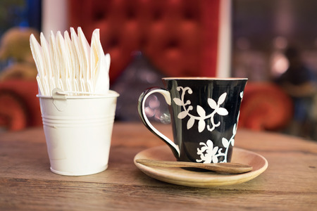 hot coffee with tissue paper coffee on wooden table coffee coffee near red sofaの写真素材