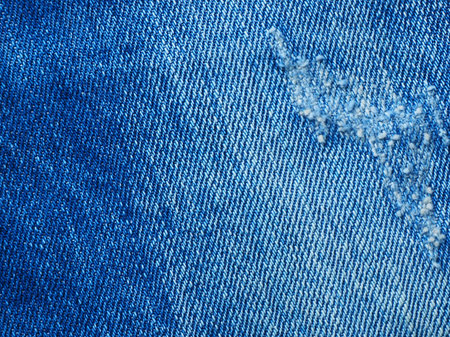 Close up blue jeans fabric texture. denim texture background with seam. Diagonal weaving jean cloth, canvas. Textile for decor, upholstery, garment. Wallpaper, backdrop.の写真素材