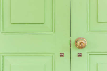 Vintage golden knob on the green wood door. Croped composition.の写真素材