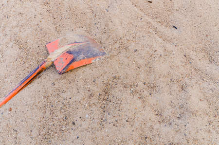 The old orange shovel in sand  pile at  construction siteの写真素材