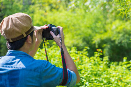 Traveller shooting a DSLR camera in forestの写真素材