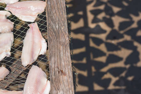 Fish on a grill to dry by the sun for preservation. Selective Focus.の写真素材