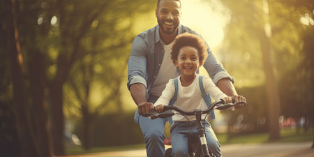 African american couple riding a bike in the park. They are smiling and looking at camera.の素材