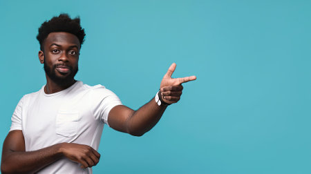 Young african american man pointing at copy space on blue backgroundの素材
