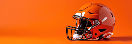 3d rendering of american football helmet on orange background with copy spaceの素材