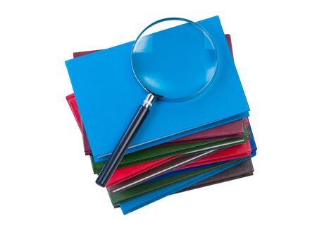Stack of books with magnifying glass isolate on white background.