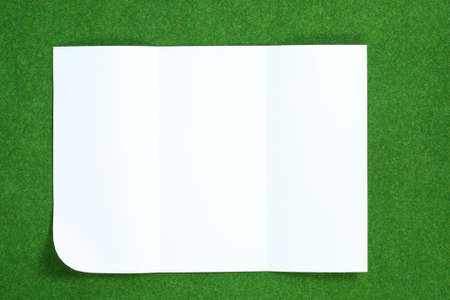 paper folded and wrinkled on grass background の写真素材