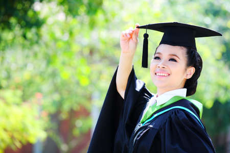 Portrait of a graduation female student looking up outdoors の写真素材