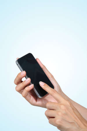 female hand touch screen on smartphone over blue background 