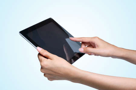 female hands holding a tablet pc  on blue background