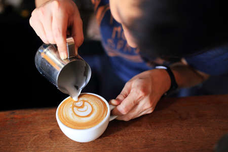 Barista pouring Latte art coffee close up.の写真素材
