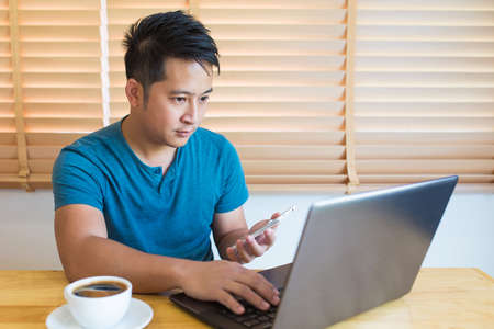 Young man wearing casual cothes working at home.の写真素材