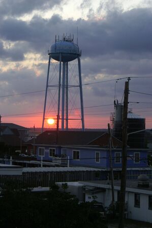 A view of the setting sun through a water towerの写真素材