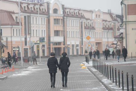 Two young ladies walk holding hands in Minsk, Belarusのeditorial素材