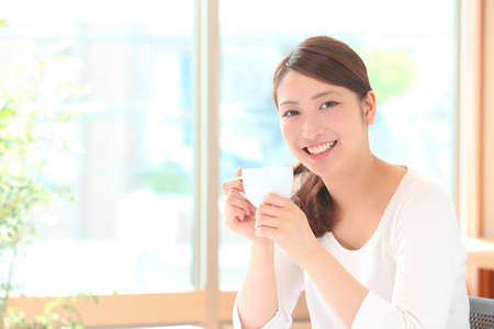 Young woman drinking coffeeの写真素材