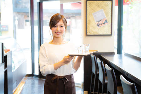 A girl working part-time at a cafÃ©の写真素材