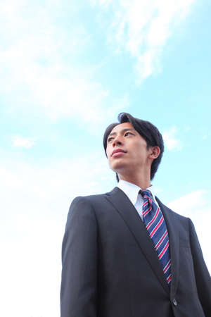 Blue Sky and Young Businessmanの写真素材