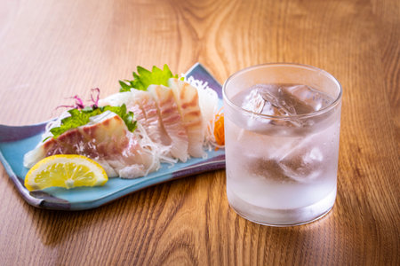 Shochu and sea bream sashimi from a Japan izakayaの写真素材