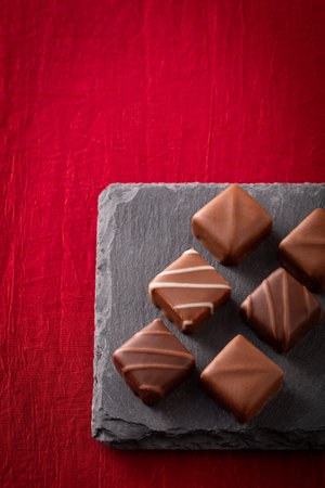 chocolates on a black slate plate on a red background.の写真素材