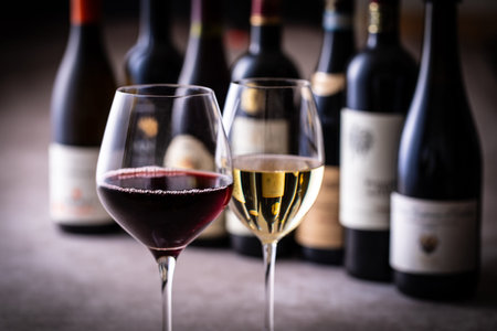 bottles and glasses of red and white wine on a dark background