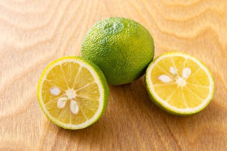 Lime fruit on wooden background. Whole and halved citrus fruit.