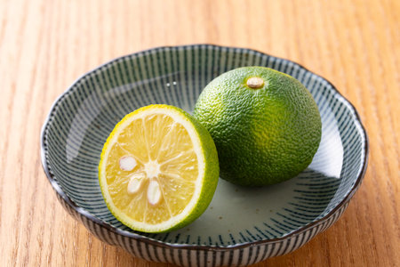 Citrus fruit, lime and lemon in a bowl on wooden table