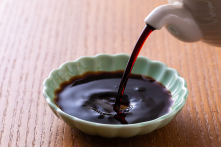 Pouring into a bowl on a wooden table close upの写真素材