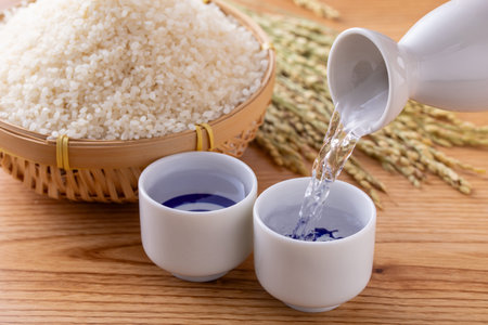 Rice in a bowl and rice in a basket on wooden backgroundの写真素材
