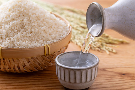 Pouring rice into a bowl on wooden table. Close up.の写真素材