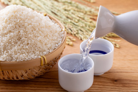 White rice in bamboo basket and rice bowl on wooden table background.の写真素材