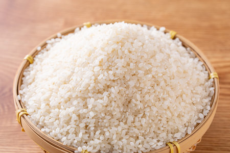 Japanese rice in bamboo basket on wooden background, close-up.