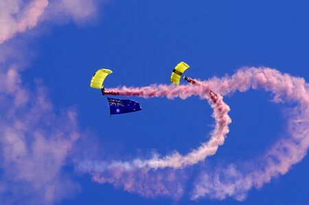  Two Skydivers Parachuting holding a Australian flag with Pink smoke on Australia Day Celebrations.                               の写真素材