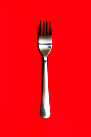 Metal fork on red backgroundの写真素材