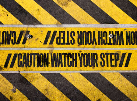 Watch your step yellow and black warningの写真素材