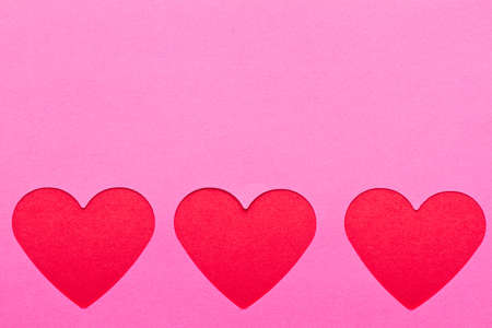Red hearts on pink paperの写真素材