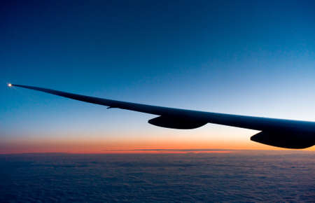 View of sunset from airplane wingの写真素材