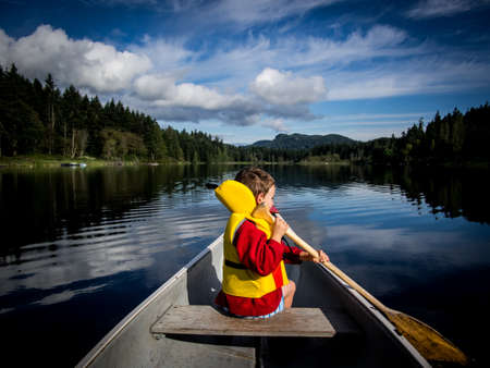 Child canoeing on lakeの写真素材
