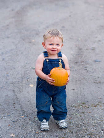 Happy boy holding pumpkinの写真素材
