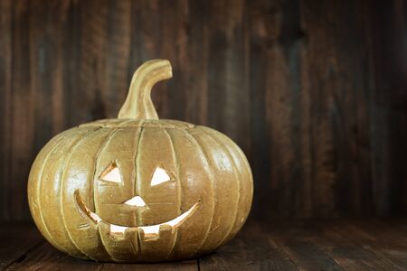 Jack-o'-lantern sitting on wood with fire insideの写真素材