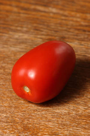 portrait solitary tomato on timber tableの写真素材