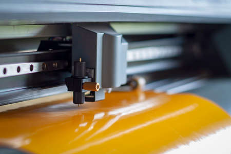 Cutting plotter close-up. The process of cutting a vinyl film.の写真素材