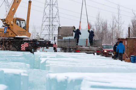 Russia, Surgut, November 19, 2018: Workers load ice blocks for transportation to the place of...