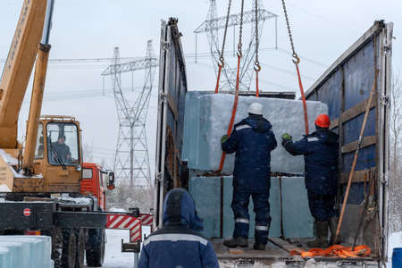 Russia, Surgut, November 20, 2018: Workers load ice blocks for transportation to the place of creation of ice sculptures.のeditorial素材