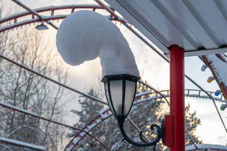 Scene snowy winter in Siberia. Big unusual snow hat on a street lamp.の写真素材