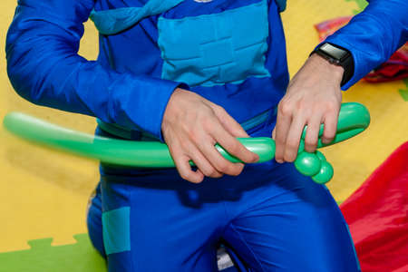 Clown makes figures from balloons. Close up.