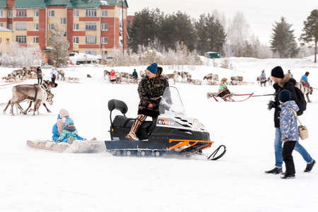 Settlement Russkinskaya, Surgut, Russia, 03/23/2019: An open traditional holiday of the peoples of Siberia. Feast of reindeer herders and fishermans. Ride on a modern snowmobile.のeditorial素材