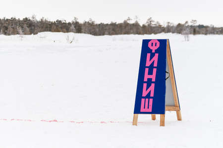 Russkinskaya, Surgut, Russia, 03/23/2019: open traditional holiday of reindeer herders and fishermen, indigenous peoples of Siberia. The finish line and the sign that says FINISH.のeditorial素材