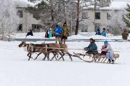 Russkinskaya, Surgut, Russia, 03/23/2019: open traditional holiday of reindeer herders and fishermen, indigenous peoples of Siberia. Aborigines-Khanty ride children on a reindeer sleigh.のeditorial素材
